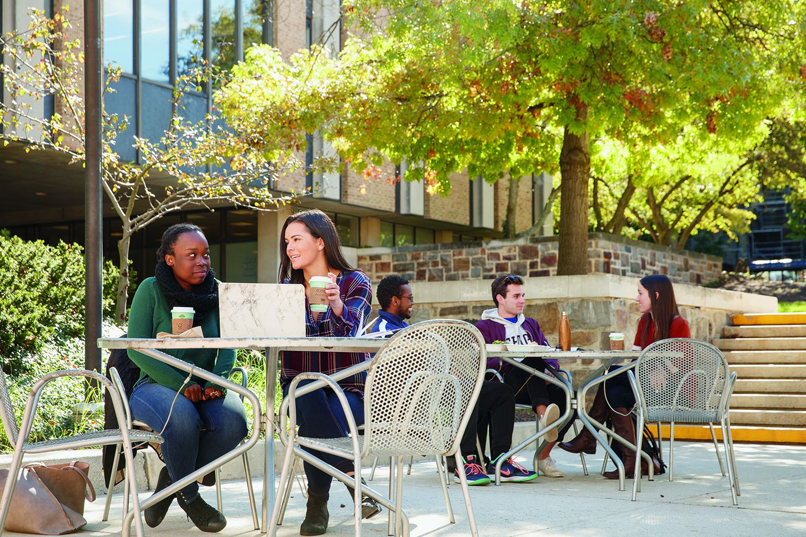 Lehigh students talking at outdoor tables on the Asa Packer campus