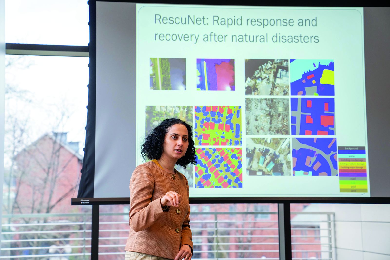 Maryam Rahnemoonfar presenting RescuNet, a project on rapid response and recovery after natural disasters, beside segmented aerial imagery