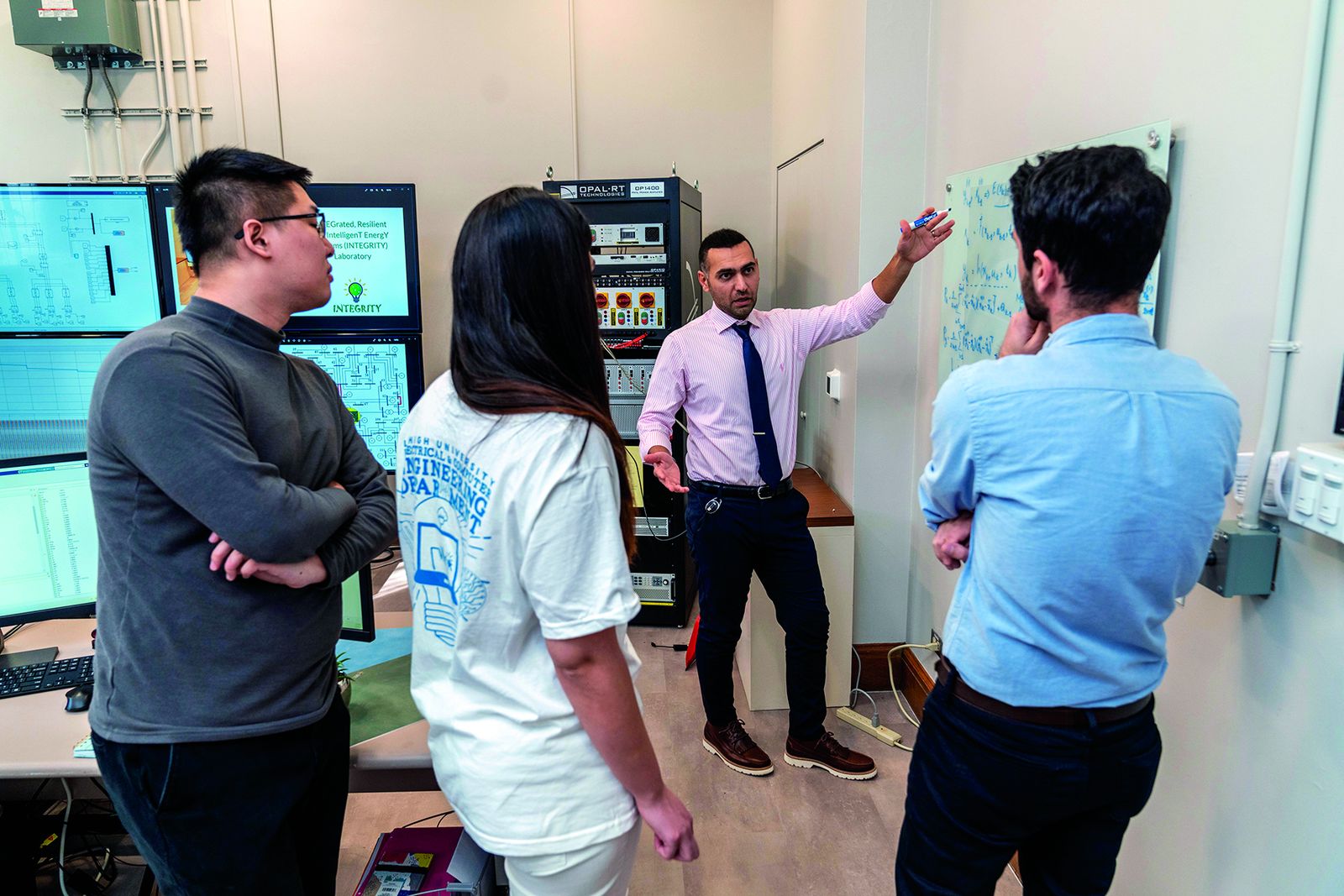 Lehigh graduate students and faculty working at a whiteboard in an instrumented engineering laboratory