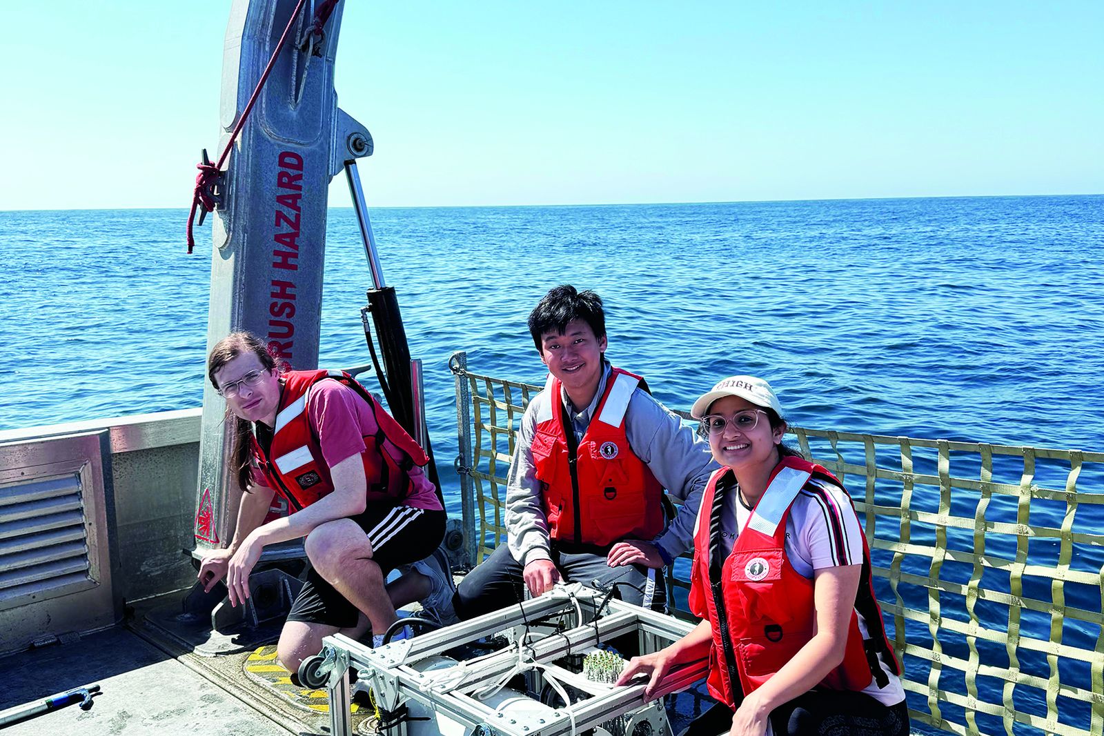 Lehigh students deploying underwater wireless research equipment from a vessel at sea