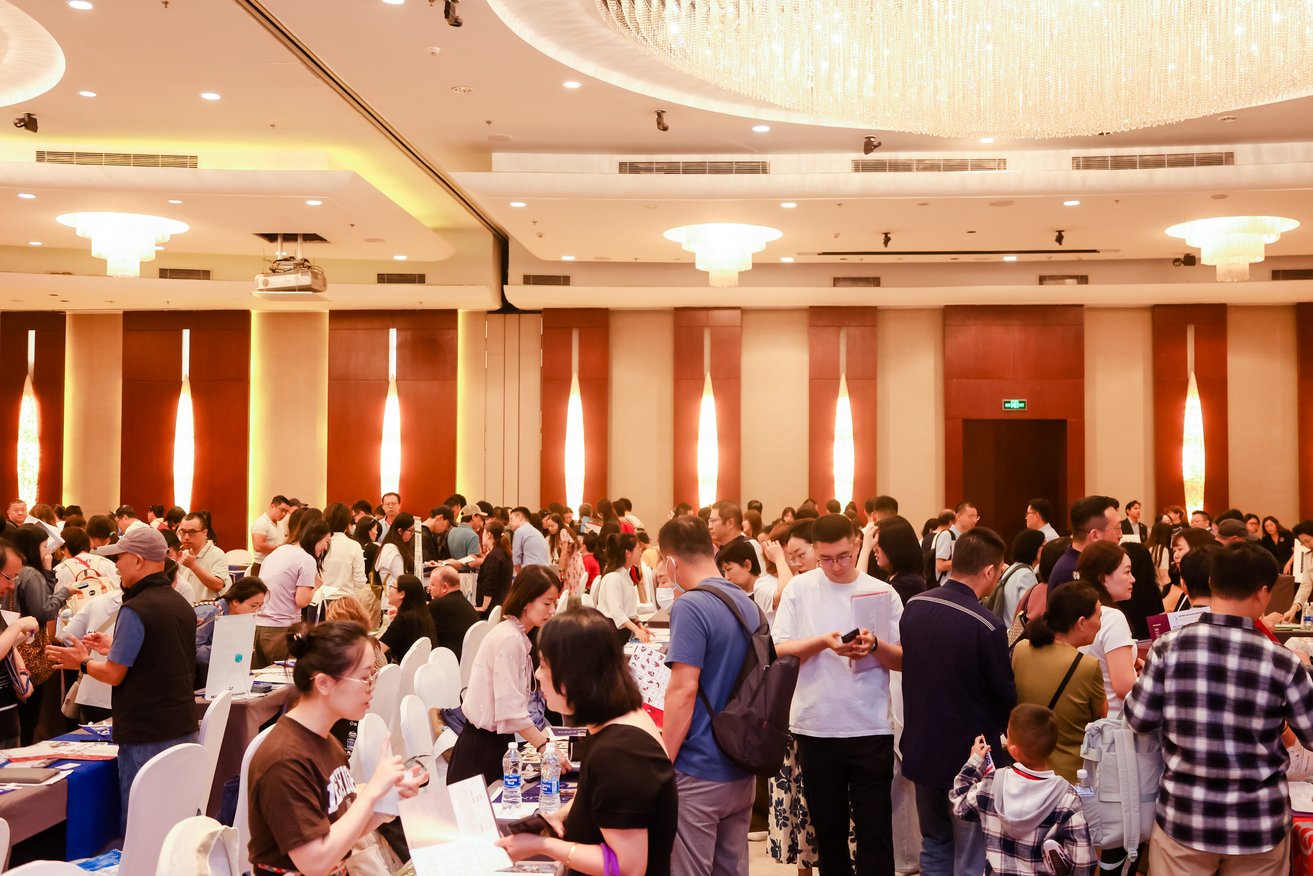 Prospective students and families visit university booths at a China graduate education fair.