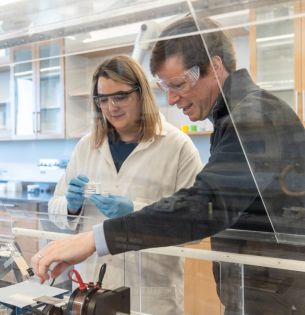 James Gilchrist working with student in lab