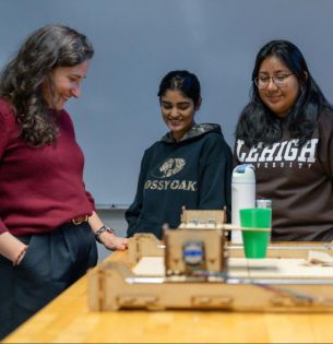 Prof. Christina Haden observes machine with two students