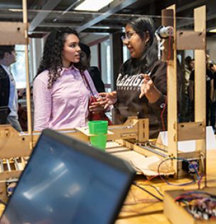 Students discuss a machine that was built in the FYRE program