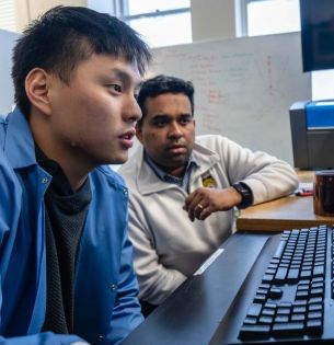 Student and Prof Seshadri look at computer