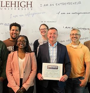 Michael Lehman in center of group photo holding award