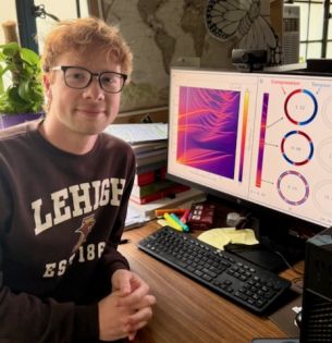 N. Dudko in front of computer with research data