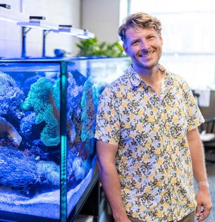 Patrick Clasen standing next to an aquarium