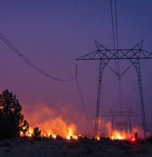 Wildfire behind power lines