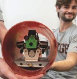 LURA members hold a robotic dog, the payload for their rocket