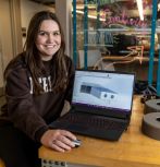 Hannah Peik with laptop and elements of Mars Rover project