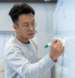 Guangyi Liu writes on whiteboard
