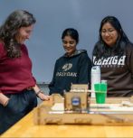 Prof. Christina Haden observes machine with two students