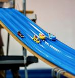 Student built and designed mini race cars go down the track