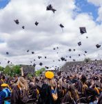 Graduates toss caps into cloudy skies at the 2025 undergraduate Commencement