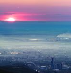 sun with smog over city