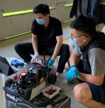 Robotics students working with car