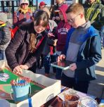 Maegan Anderson helps young IronPigs fan with Robot Baseball activity