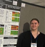 Katie Atherton standing by her research poster
