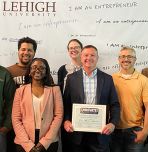 Michael Lehman in center of group photo holding award