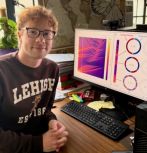 N. Dudko in front of computer with research data