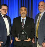 Amit Varma (center) with AISC leadership presenting award (Photo courtesy of Purdue University and AISC)