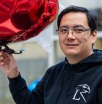David Saldaña holding drone attached to red mylar balloon