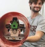 LURA members hold a robotic dog, the payload for their rocket