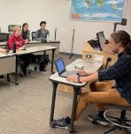From left, Eddie Fuhrer ’25, Diana Shaipi ’24, Gregory Lin ’23, Josh Miller, Sasha Rabeno ’24, Marietta Sisca ’23 and Eric Yang ’25 at a Quiz Bowl practice in March. Club founder Will Yaeger ’23 is seated up front asking questions.